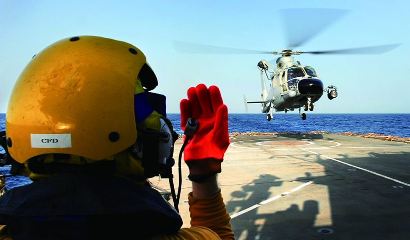 英國海軍巡防艦上的著艦指導員正在引導一架中國海軍的直九直升機著艦，反海盜任務需要國際合作才能發揮效果。